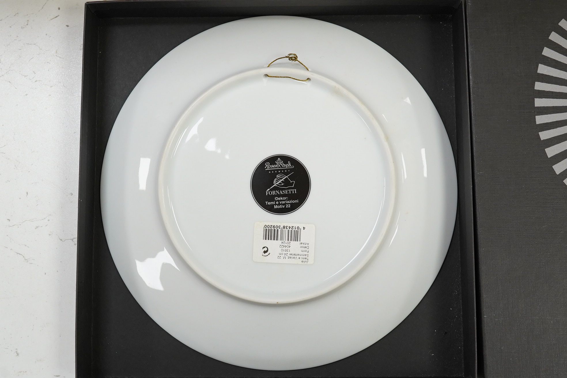 A boxed Rosenthal Fornasetti plate, 23.5cm in diameter. Condition - good